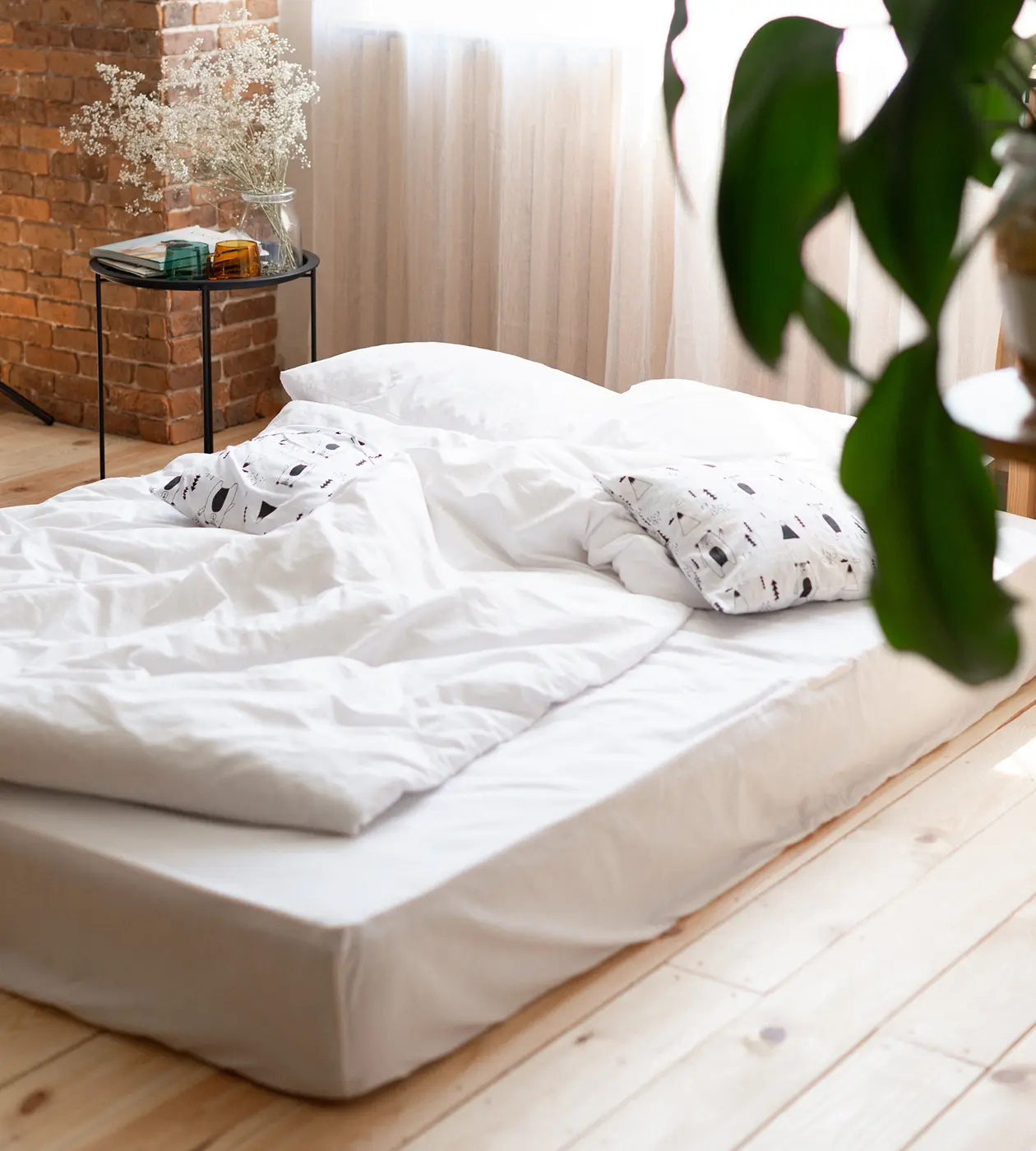 A neatly made white bed featuring a smooth white sheet, creating a clean and serene sleeping environment.